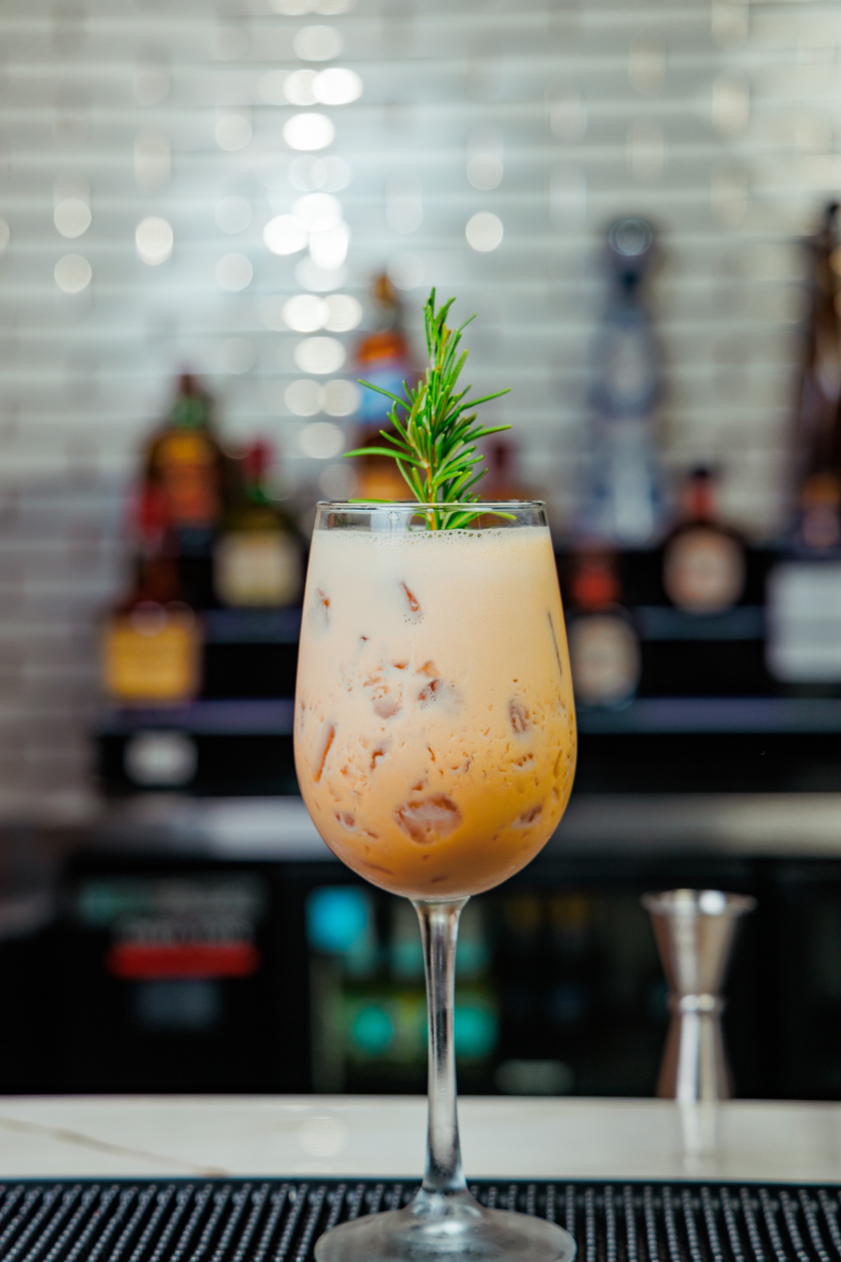 Creamy horchata-style cocktail with rosemary garnish